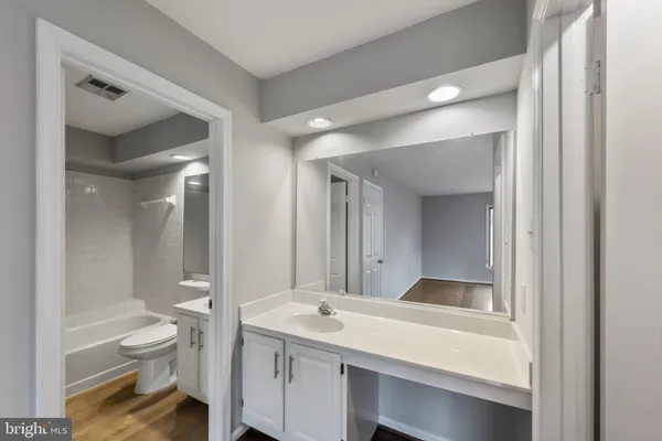 a bathroom with a granite countertop sink toilet a large mirror and shower