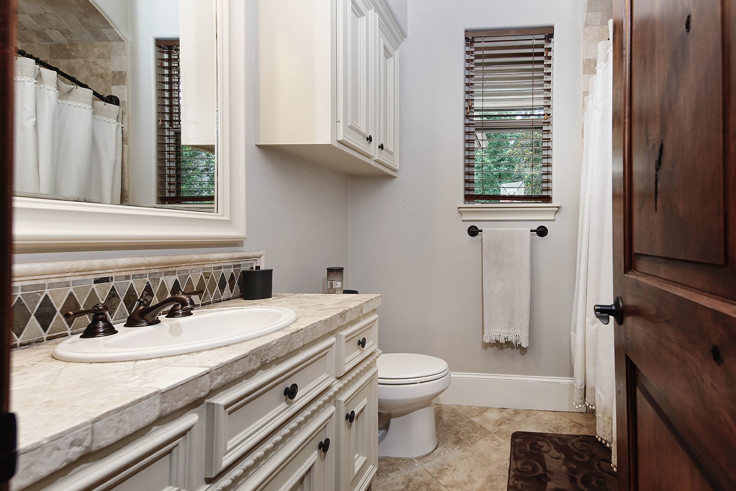 119 Angel Leaf Road The Woodlands, TX 77380 - Photo 32 of 50 a bathroom with a sink a toilet and a window