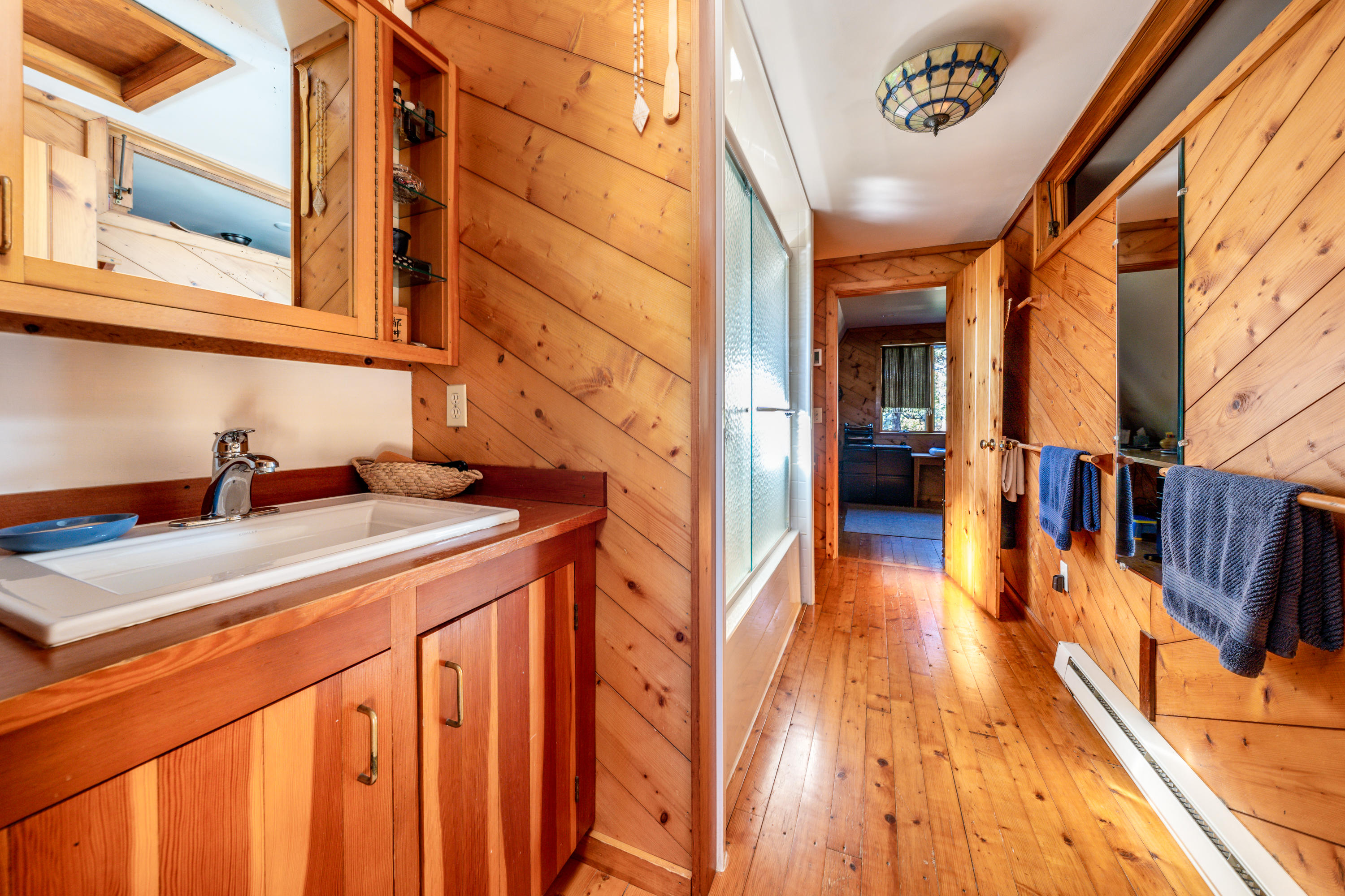80 Peace Valley Road Wellfleet, MA 02667 - Photo 25 of 52 a hallway with a sink and wooden floor
