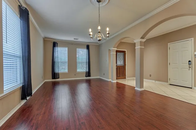 an empty room with wooden floor and mirror