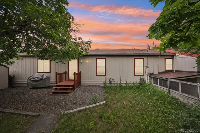a view of a house with backyard and sitting area