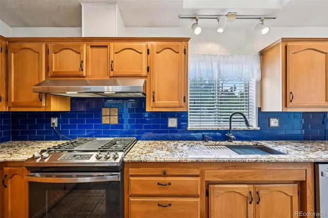 a kitchen with granite countertop cabinets stove and sink