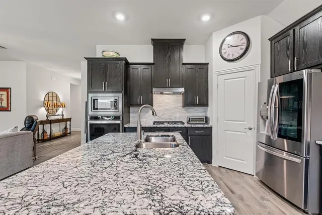 a kitchen with stainless steel appliances granite countertop a refrigerator stove and oven