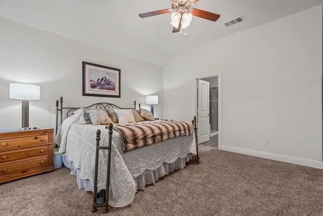 a spacious bedroom with a bed and a chandelier
