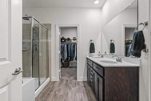 a bathroom with a double vanity sink a mirror and shower