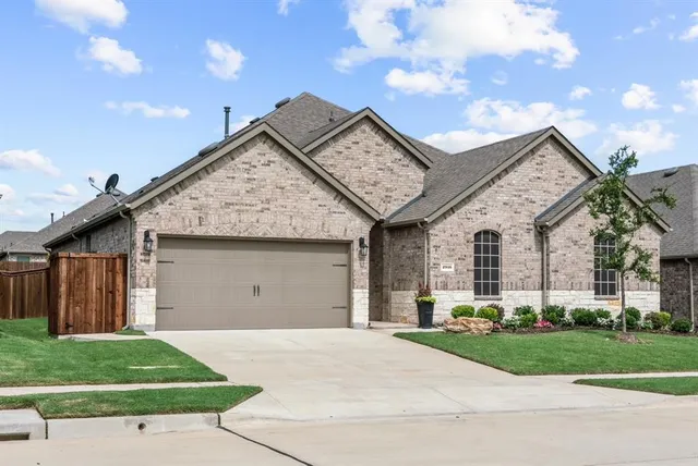 a front view of a house with a garden and garage