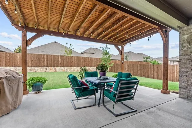 a view of a patio with a table chairs and a backyard