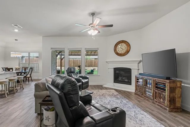 a living room with furniture a fireplace and a flat screen tv