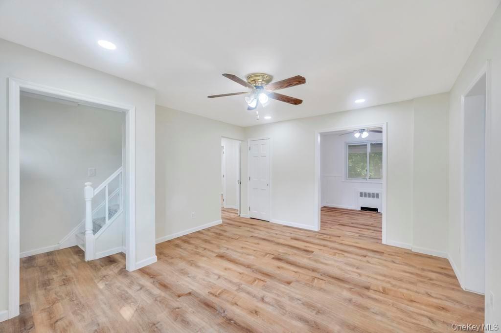 815 Udall Road West Islip, NY 11795 - Photo 13 of 45 Unfurnished room featuring ceiling fan, light wood finished floors, radiator heating unit, stairway, and recessed lighting