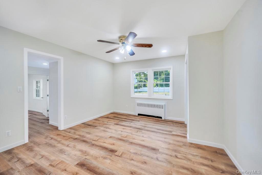 815 Udall Road West Islip, NY 11795 - Photo 15 of 45 Empty room with light wood-type flooring, radiator, ceiling fan, and recessed lighting