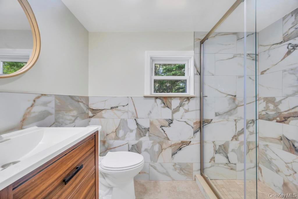 815 Udall Road West Islip, NY 11795 - Photo 16 of 45 Bathroom with vanity, a marble finish shower, and tile walls
