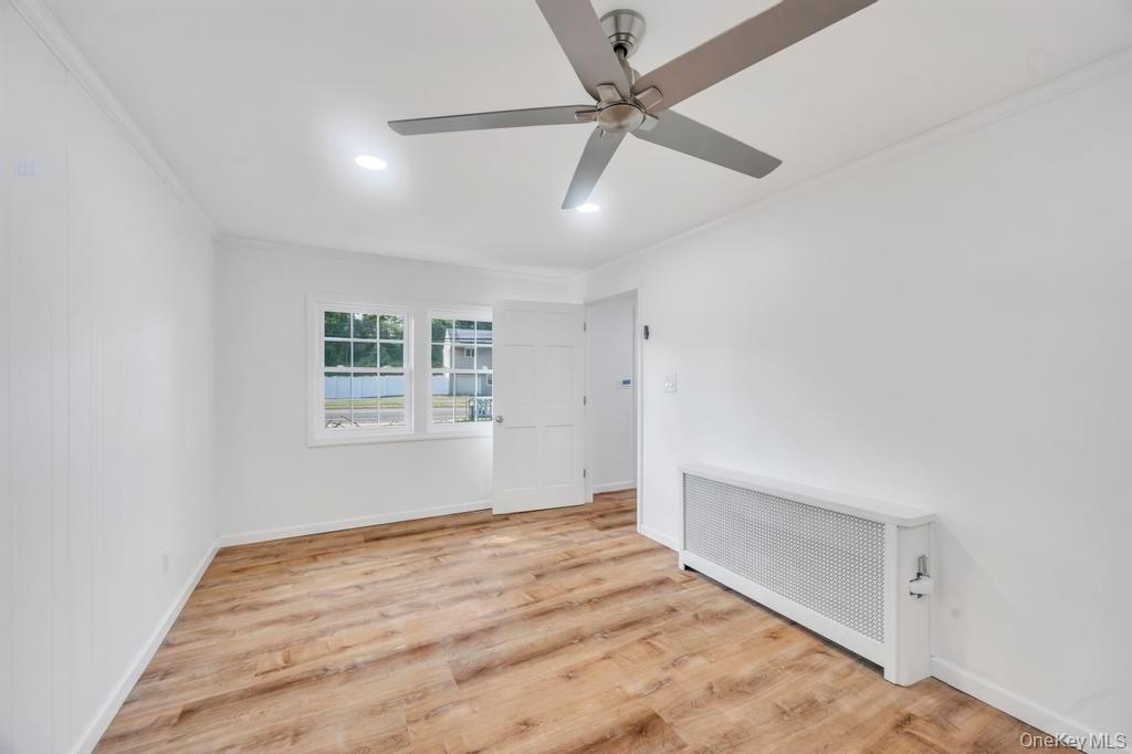 815 Udall Road West Islip, NY 11795 - Photo 20 of 45 Unfurnished room with radiator heating unit, crown molding, light wood-type flooring, and recessed lighting