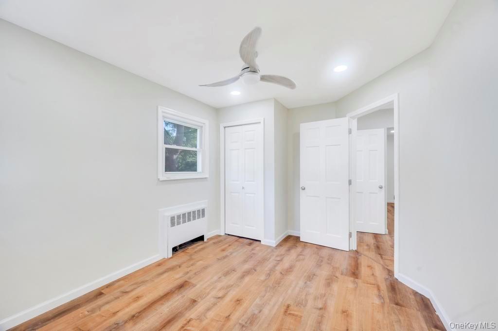 815 Udall Road West Islip, NY 11795 - Photo 34 of 45 Unfurnished bedroom featuring light wood-style floors, radiator heating unit, ceiling fan, a closet, and recessed lighting