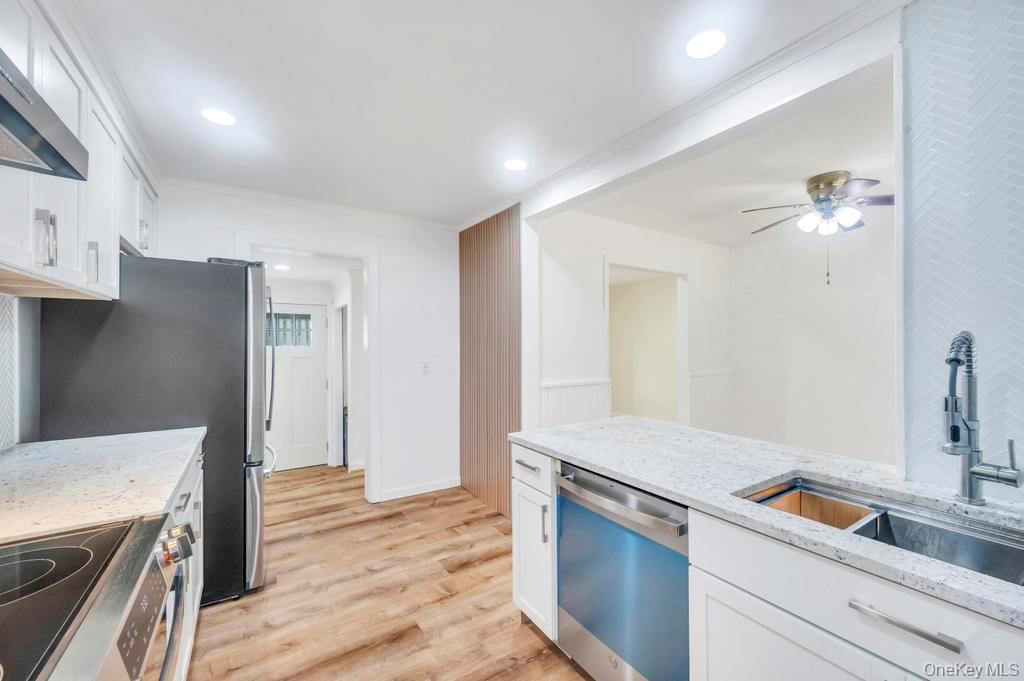 815 Udall Road West Islip, NY 11795 - Photo 7 of 45 Kitchen featuring white cabinets, light stone counters, stainless steel appliances, light wood finished floors, and recessed lighting