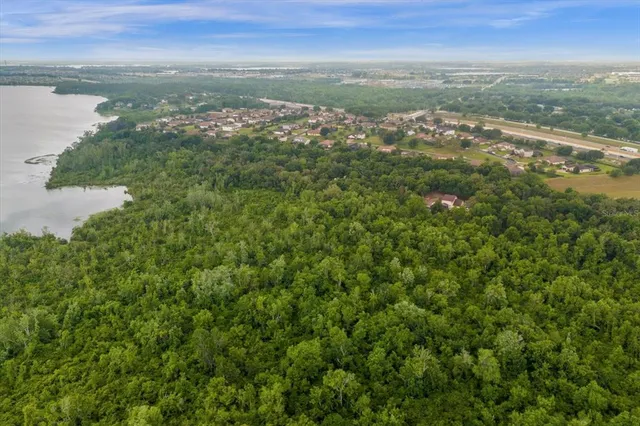 an aerial view of residential houses with outdoor space and lake view