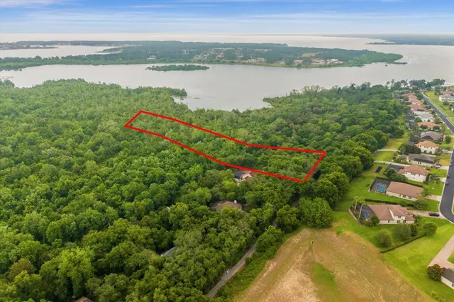 an aerial view of a houses with a yard and mountain view