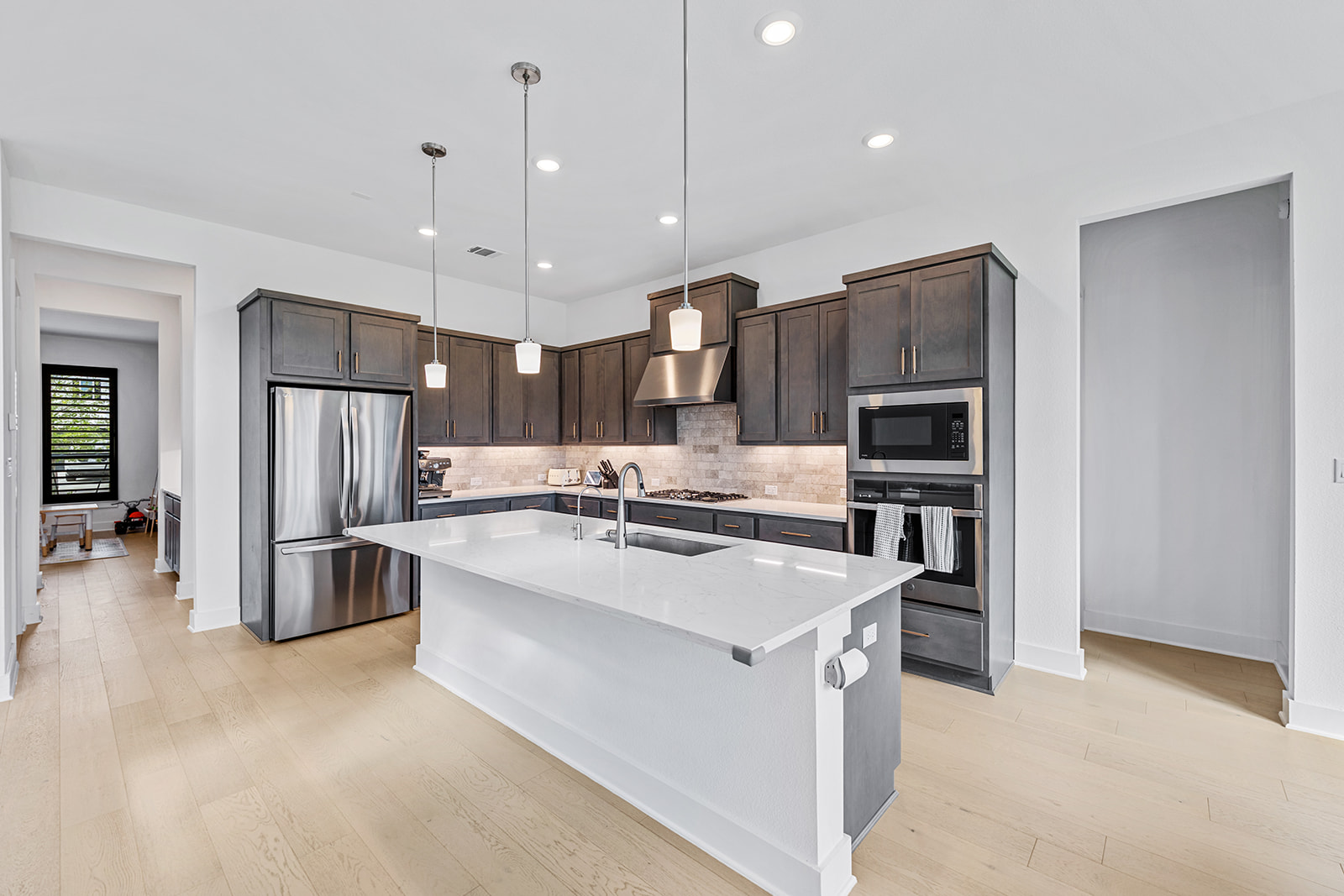 2905 Canto Trace Leander, TX 78641 - Photo 11 of 40 a large kitchen with stainless steel appliances kitchen island a large counter top a stove a refrigerator and a sink