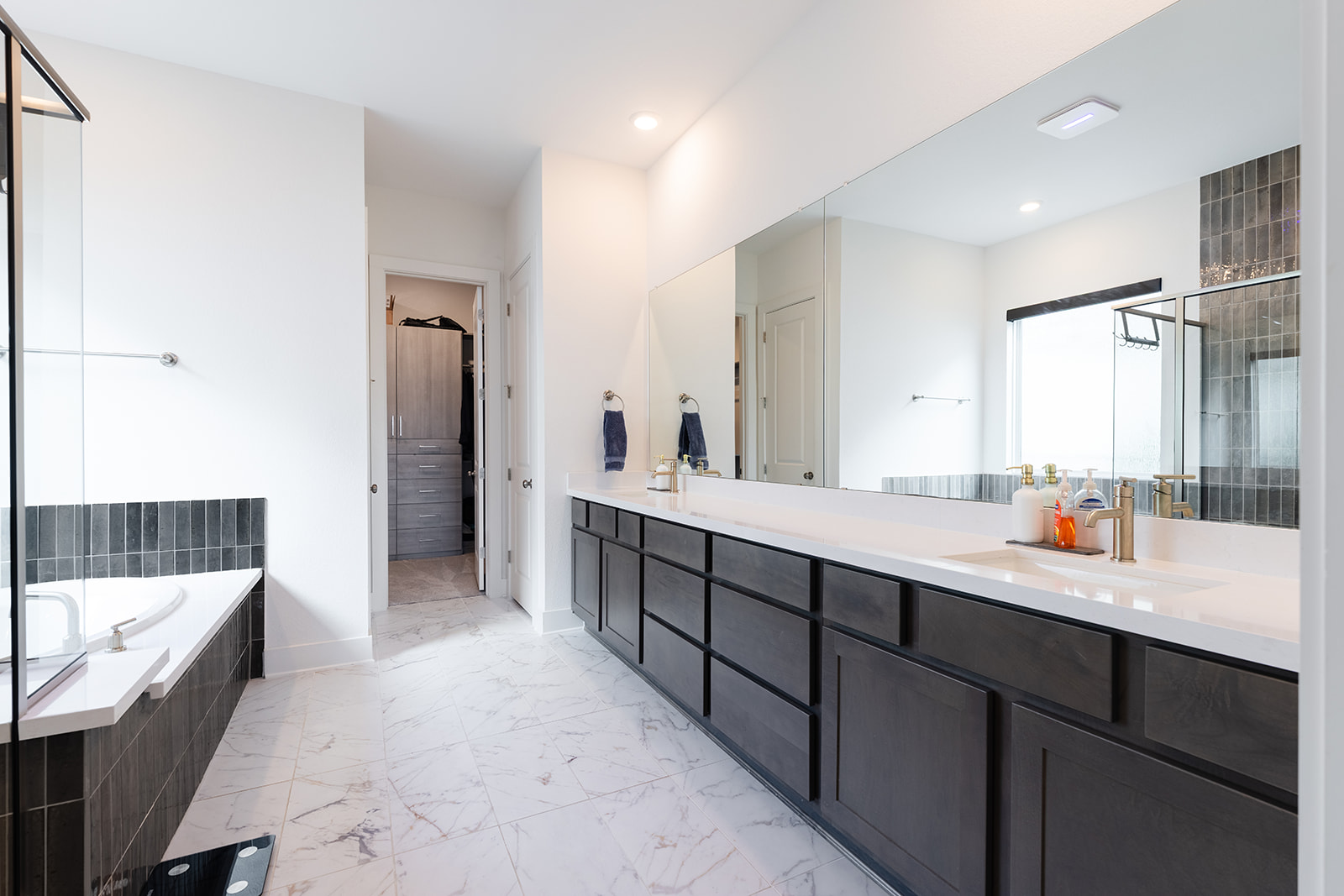 2905 Canto Trace Leander, TX 78641 - Photo 17 of 40 a large bathroom with a double vanity sink a mirror and a bathtub