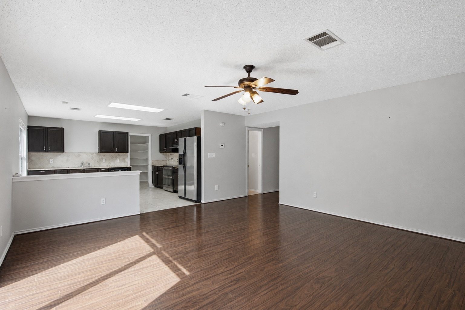 7900 Rosenberry Drive Austin, TX 78747 - Photo 5 of 27 A streamlined open-concept design connects the kitchen and living areas, offering effortless daily living.