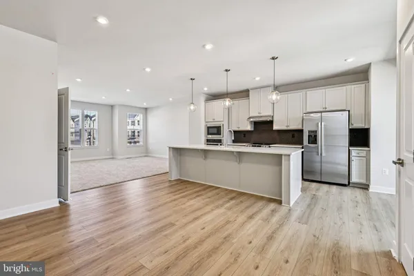 a large kitchen with stainless steel appliances refrigerator sink and cabinets