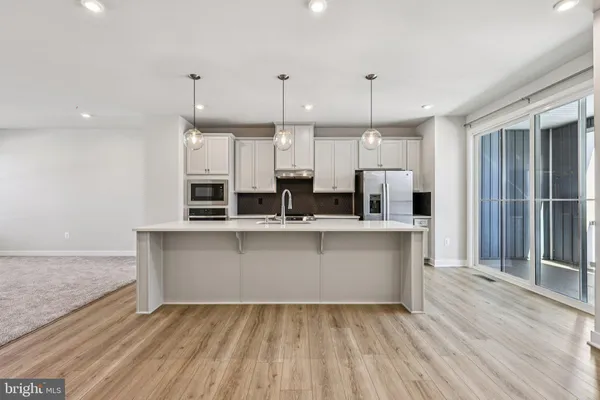 a large kitchen with kitchen island a sink stainless steel appliances and cabinets