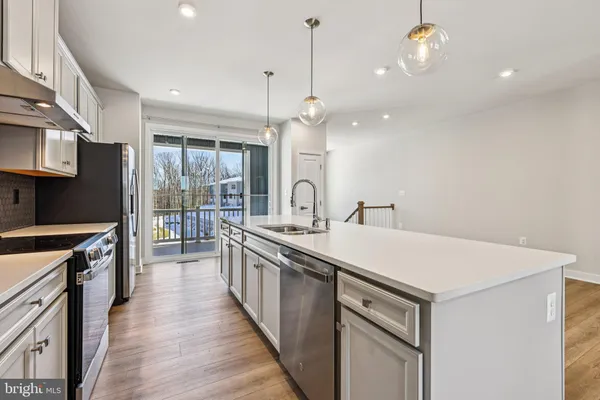 a kitchen with sink stove and refrigerator