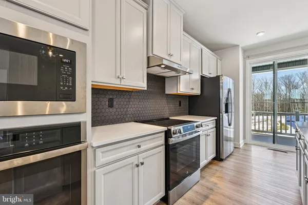 a kitchen with stainless steel appliances a stove a sink and a refrigerator