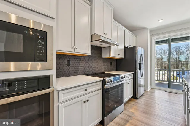 a kitchen with stainless steel appliances a stove a sink and a refrigerator
