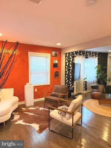 a living room with furniture a wooden floor and a large window