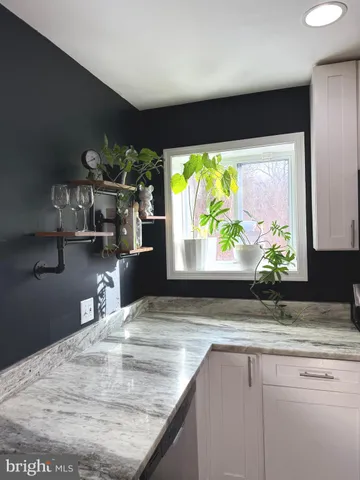 a large kitchen with stainless steel appliances granite countertop a stove a sink dishwasher and a microwave with wooden floor