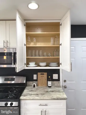 a kitchen with kitchen island granite countertop a table chairs sink and microwave