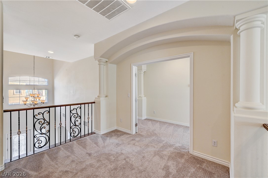 6761 Clay TABLET Street Las Vegas, NV 89149 - Photo 34 of 73 Ornate columns and a decorative iron railing define this upper-level landing with plush carpeting.