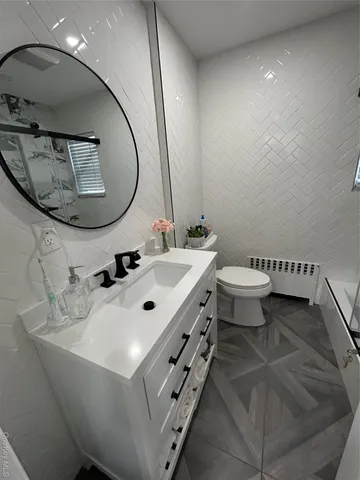 a bathroom with a sink mirror and toilet