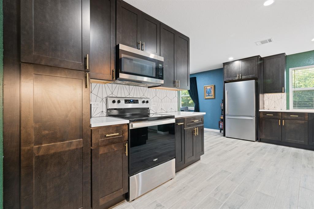 806 Colonial Drive Cleburne, TX 76033 - Photo 16 of 27 a kitchen with stainless steel appliances a refrigerator a sink a stove and microwave