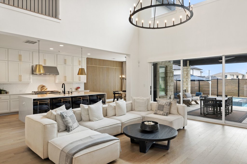 802 Geiger Path Austin, TX 78738 - Photo 18 of 40 Living room with light wood-style floors, a chandelier, and a high ceiling