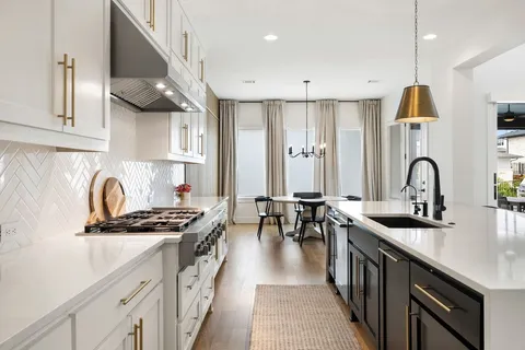 a kitchen with stainless steel appliances a sink a stove and a wooden floors