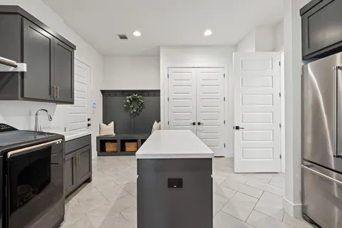 a kitchen with a refrigerator sink and cabinets