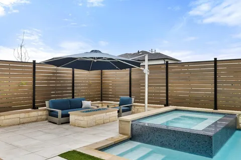 a view of a patio with couches chairs under an umbrella