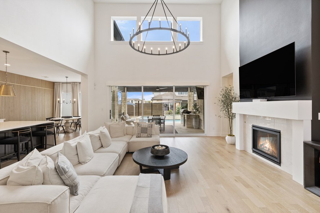 802 Geiger Path Austin, TX 78738 - Photo 5 of 40 Living room featuring soaring ceilings, light wood flooring, an abundance of natural light, a fireplace and high ceilings. Open concept living at it's finest!