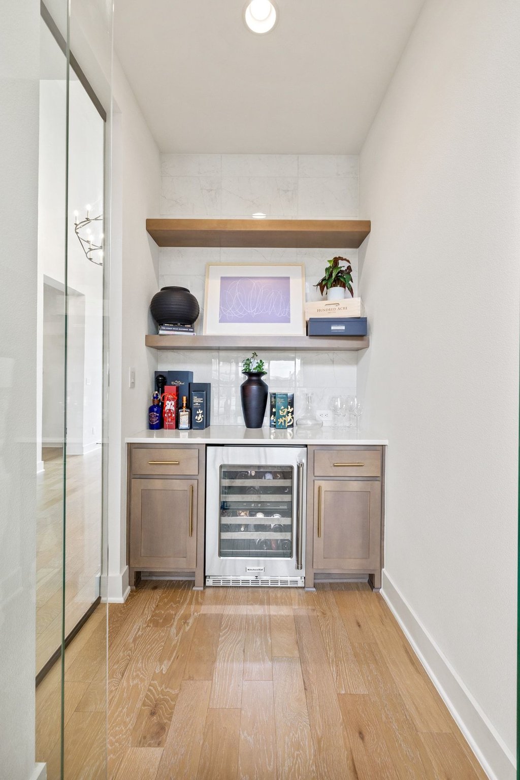 802 Geiger Path Austin, TX 78738 - Photo 10 of 40 Indoor dry bar featuring open shelves, wood finish cabinetry, and beverage cooler located off the living room for added convenience!