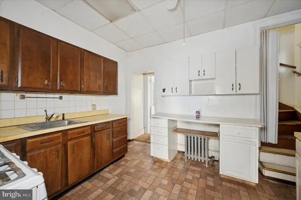 a kitchen with cabinets stainless steel appliances and wooden floor