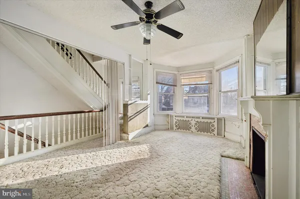 an empty room with windows and ceiling fan