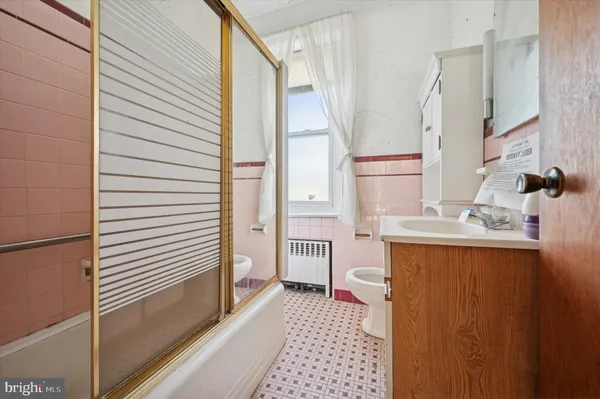 a view of an empty room with wooden floor ceiling fan