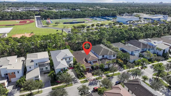an aerial view of house with swimming pool and large trees