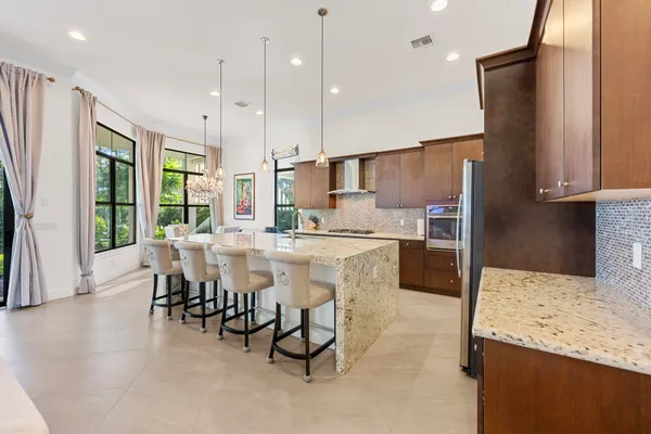 a kitchen with kitchen island a stove a table and chairs in it