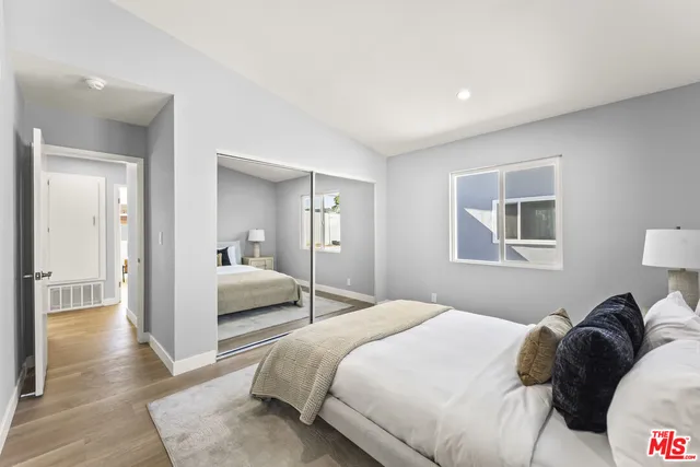 a bedroom with a bed and a large mirror