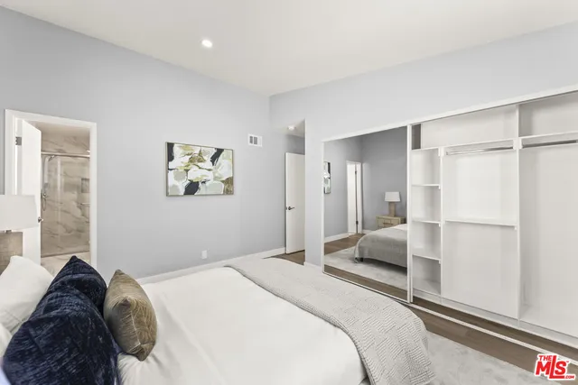 a bedroom with a bed and a large mirror