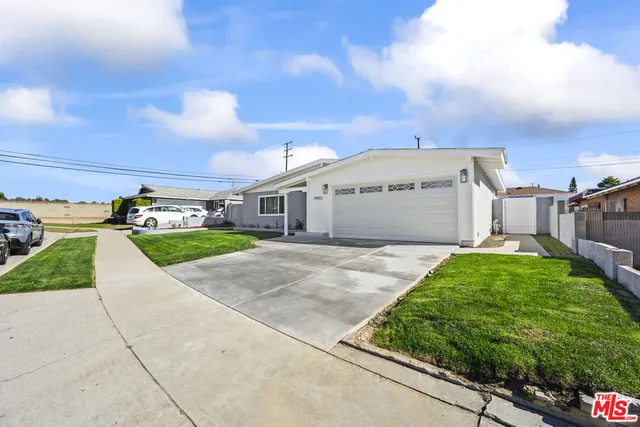 a view of a white house with a yard and table and chairs