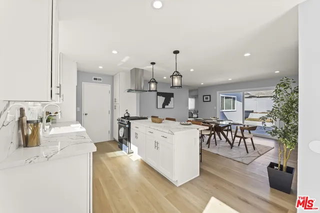 a large white kitchen with lots of counter space and furniture
