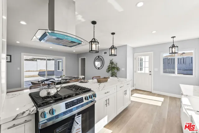 a kitchen with a stove a sink and a chandelier